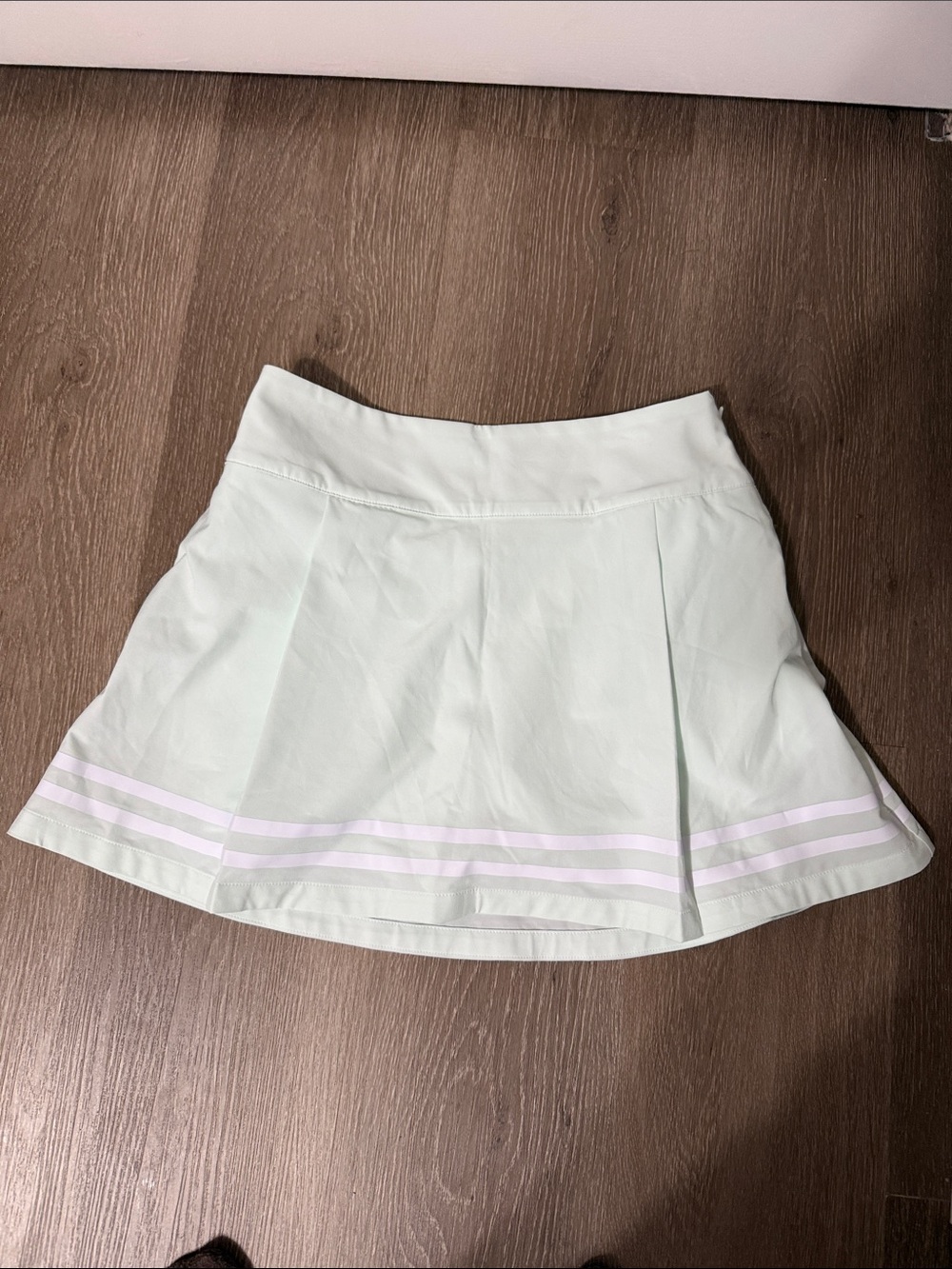Pleated Mint Green Tennis Skirt with White Stripe brand is Carrie under wood